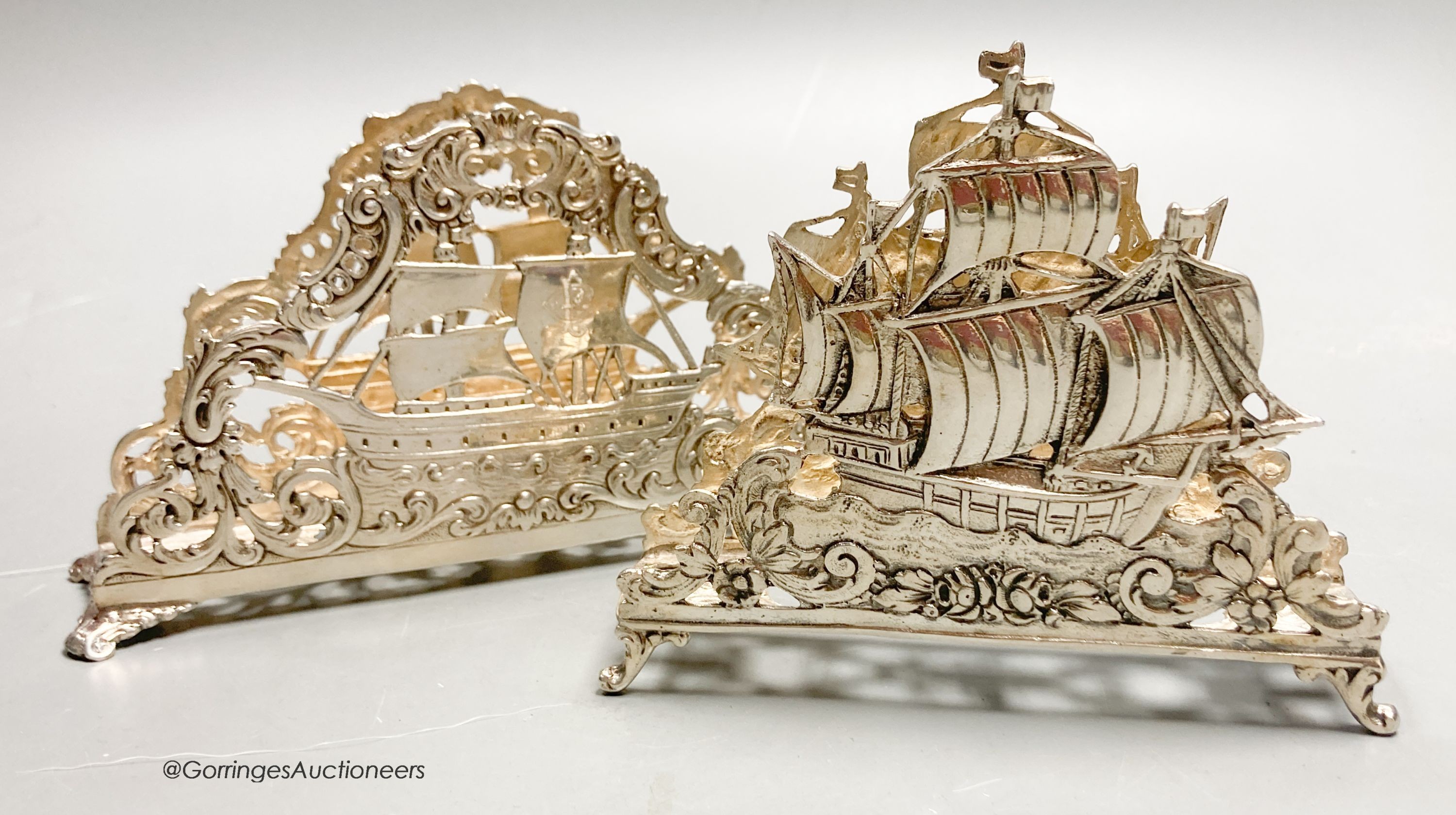 Two early 20th century German 800 standard pierced white metal letter racks, decorated with sailing ships, longest 13.8cm